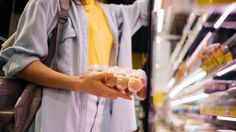 a woman buying eggs at the grocery store