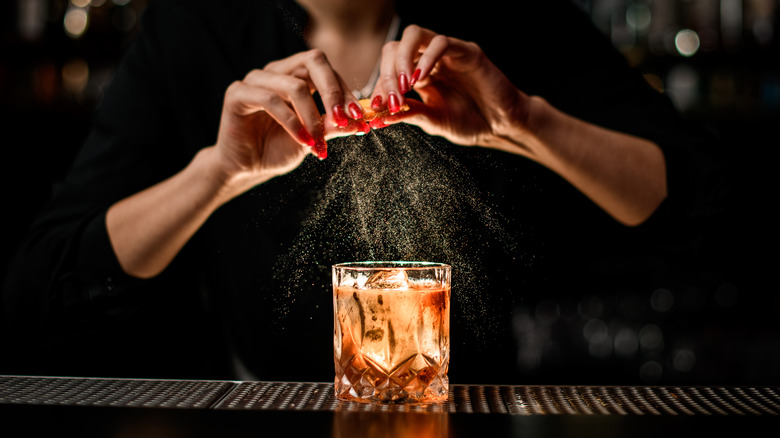 Bartender garnishes a cocktail