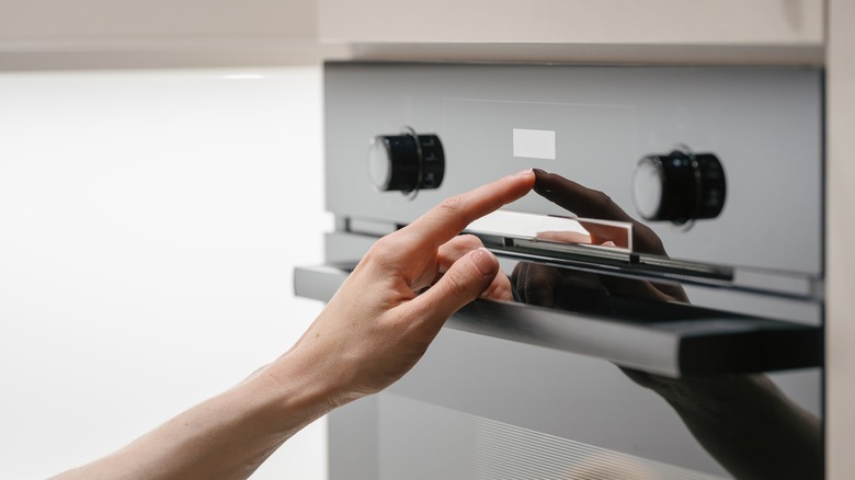 a person touching settings on an oven