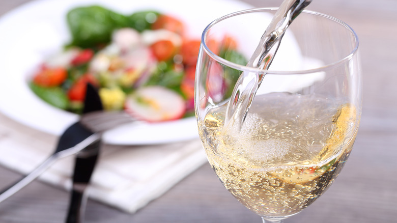 Close-up of a glass of white wine and salad