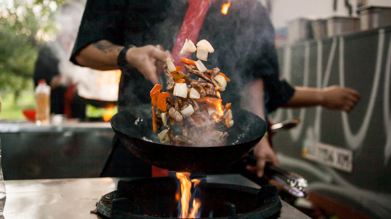 vegetables and meat being sautéed