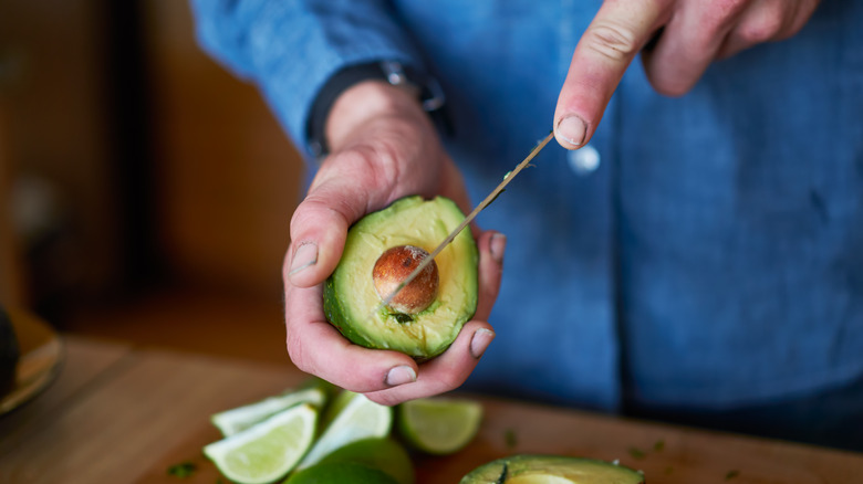 man cutting into an avocado