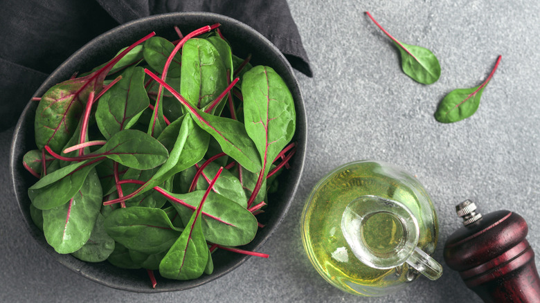 baby chard leaves in bowl with oil