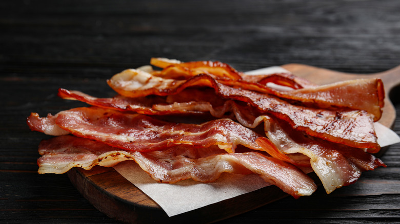 cooked bacon on wooden serving board