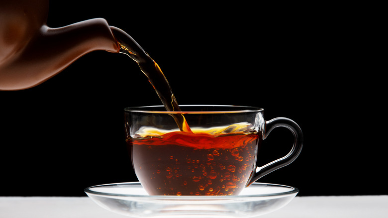 pouring black tea in glass