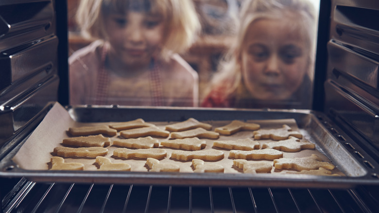 Little girls watching cookies bake