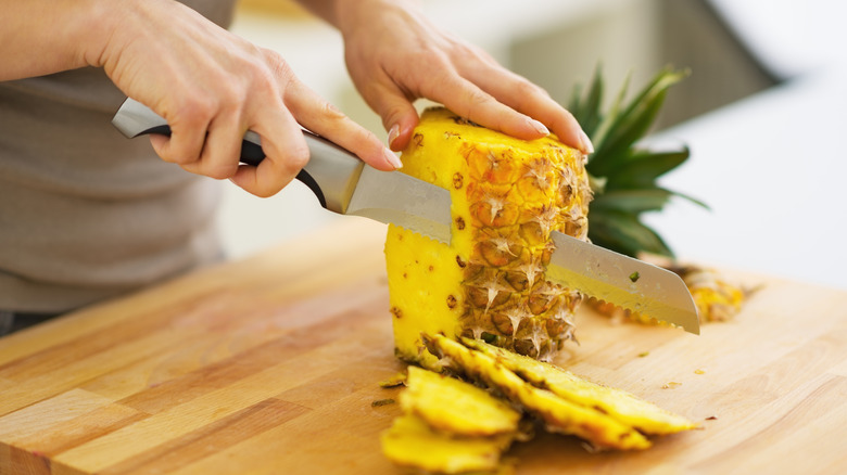 woman cutting pineapple