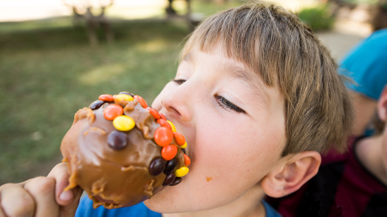 Child eating caramel apple