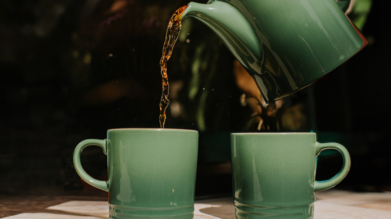 Coffee pouring into ceramic mugs