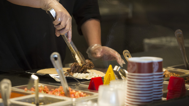 Chipotle employee prepares a meal