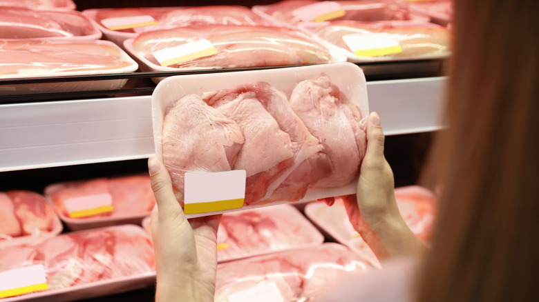 woman buying packed chicken meat