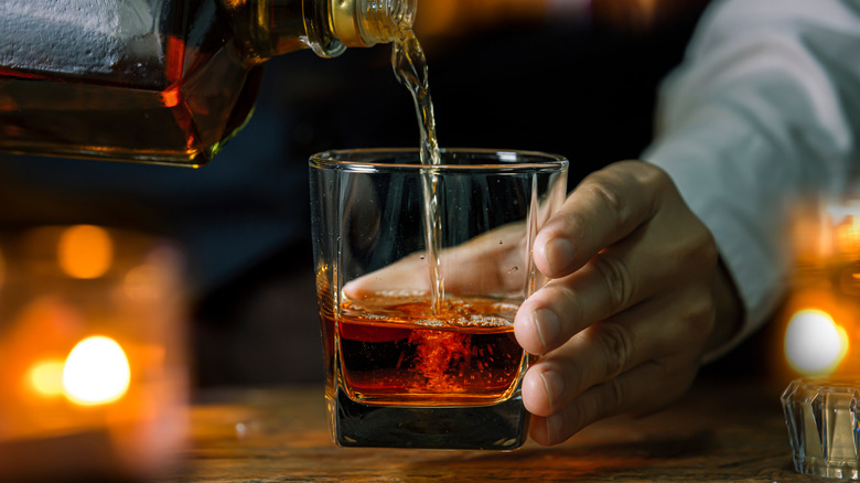 Bartender pouring whiskey into glass