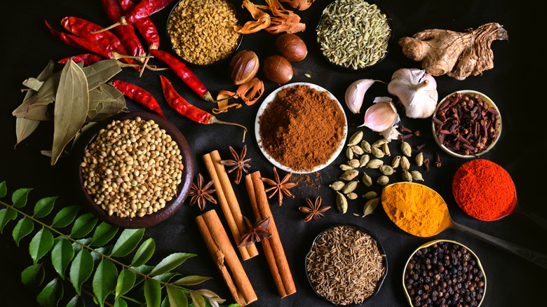 bowls and piles of various spices used in Indian cooking