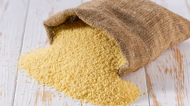 Dry couscous spilling out of a burlap sack