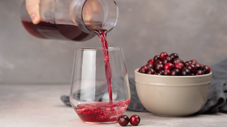 Cranberry juice pouring from carafe