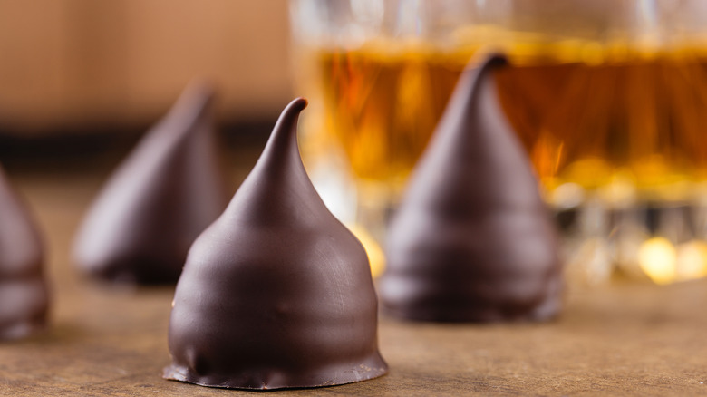 Chocolate candies with a crystal glass of bourbon in the background