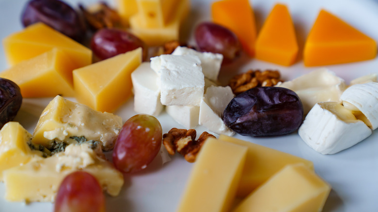 plate with cheeses grapes and date