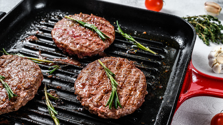 burgers cooking in a pan