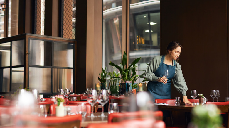 waitress setting tables at a fine-dining restaurant