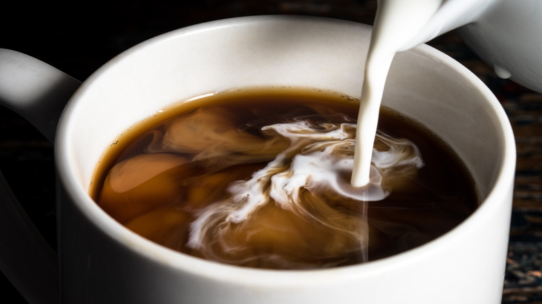 Pouring cream into coffee