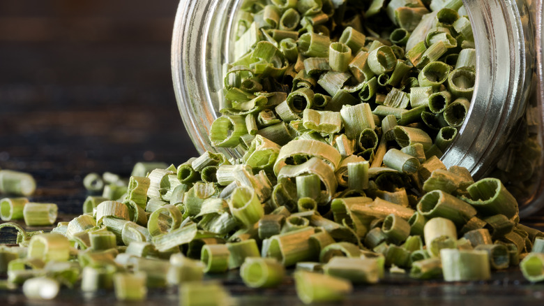 Dried chives spilling from jar 