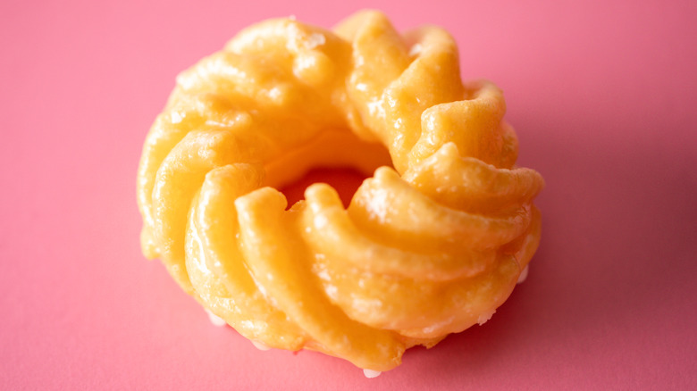 French cruller donut on pink background