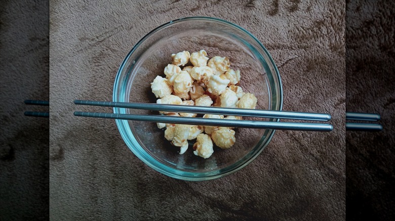 chopsticks on bowl of popcorn