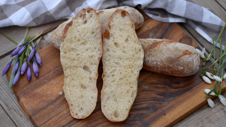 French bread halves on a wooden cutting board