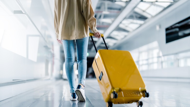 Person walking with suitcase in airport 