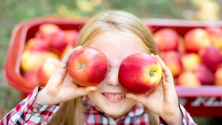 girl picking apples with wagon