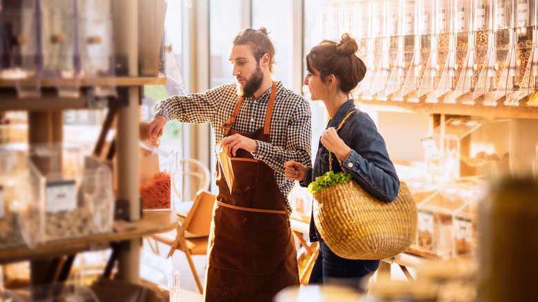 Woman with shopping assistant at grocer's