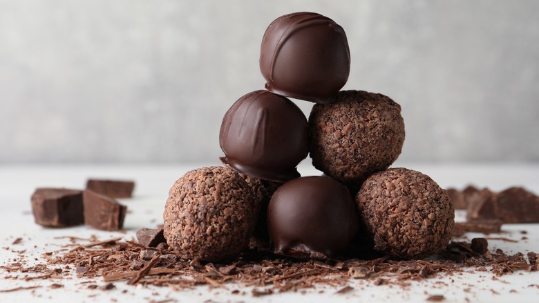 Stack of chocolate truffles on white surface 