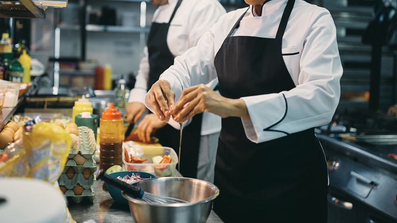 A chef cracking an egg.