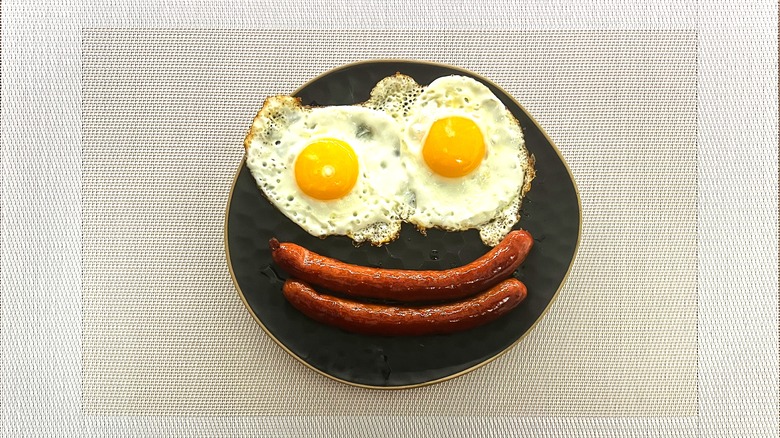 Eggs and sausage in the shape of smiley face 