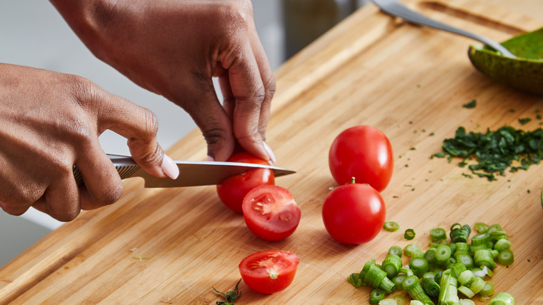 hands cutting tomatoes 