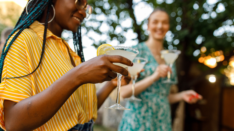 Guests smiling and holding cocktails at party