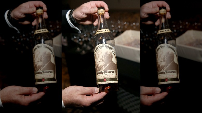 hands holding bottle of Pappy Van Winkle