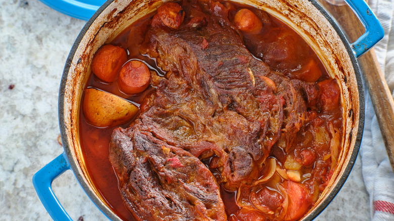 Pot roast with carrots and potatoes in Dutch oven