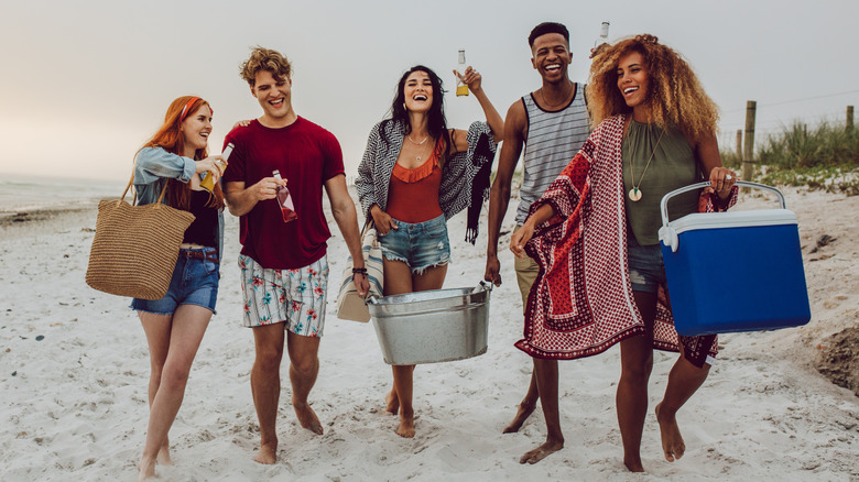 friends with coolers on beach