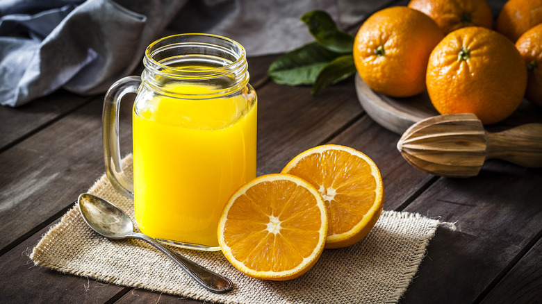 Orange juice in a glass and a halved orange