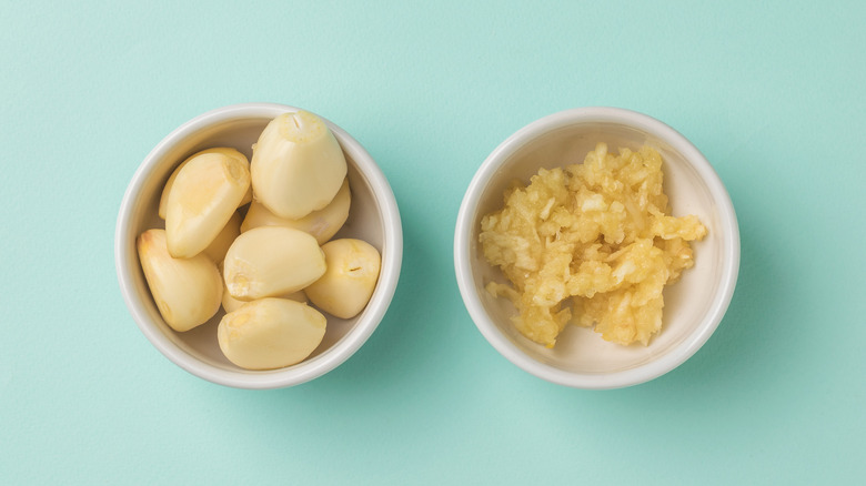 Garlic cloves in white bowls