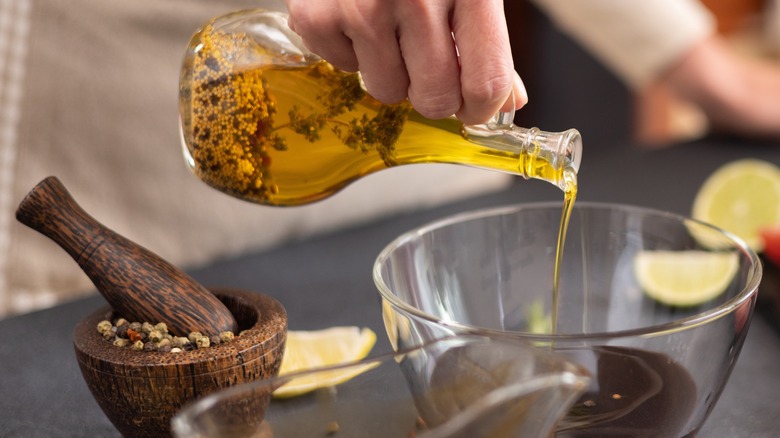 woman pouring olive oil marinade