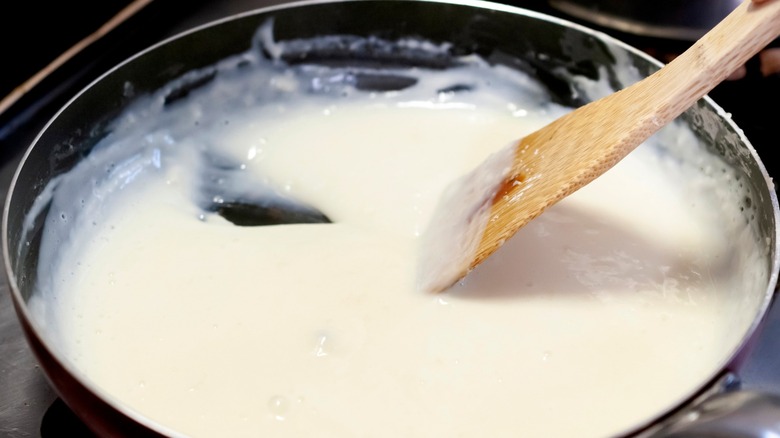 stirring creamy sauce in a pan