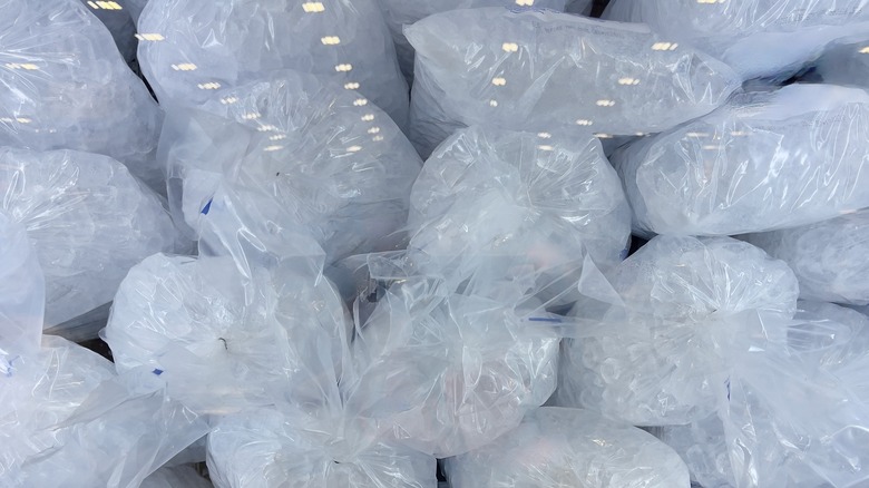 Bags of ice stacked in a freezer