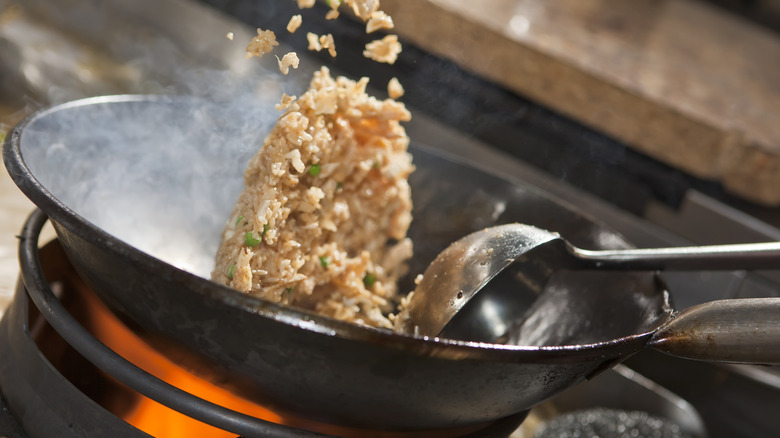 tossing fried rice in a wok