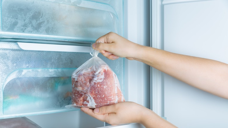 Taking frozen meat from freezer