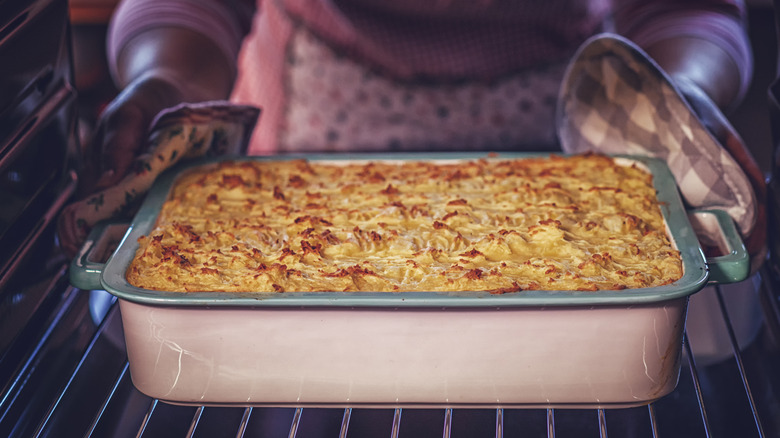 Chef removing casserole from oven