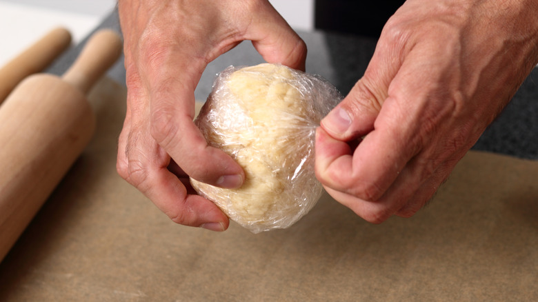 Refrigerated ball of pie dough being unwrapped