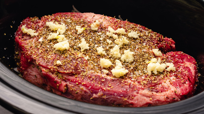 raw seasoned beef in a slow cooker