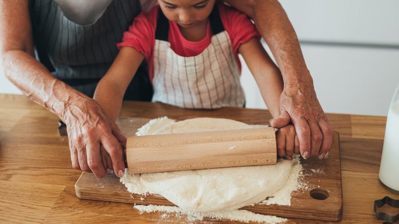 child rolling dough